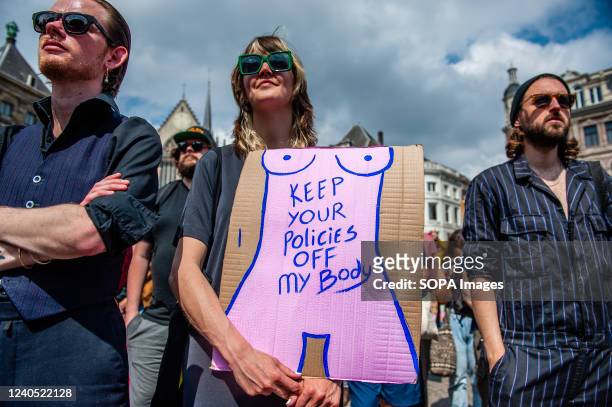 Woman standing in the middle of two men is seen holding a placard in support of women rights during the demonstration. The foundation Women's March...