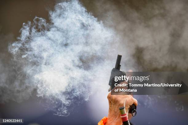 An official fires the start gun during a race at the Tom Gage Classic Track and Field Meet on May 7, 2022 in Missoula, Montana.