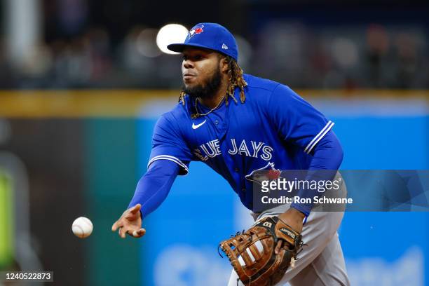 Vladimir Guerrero Jr. #27 of the Toronto Blue Jays under hands the ball to force out Jose Ramirez of the Cleveland Guardians at first base in the...