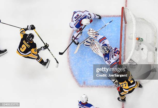 Evan Rodrigues of the Pittsburgh Penguins scores past Igor Shesterkin of the New York Rangers in Game Three of the First Round of the 2022 Stanley...