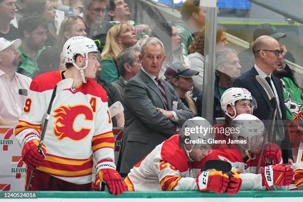 Darryl Sutter pf the Calgary Flames watches the action from behind the bench against the Dallas Stars in Game Three of the First Round of the 2022...