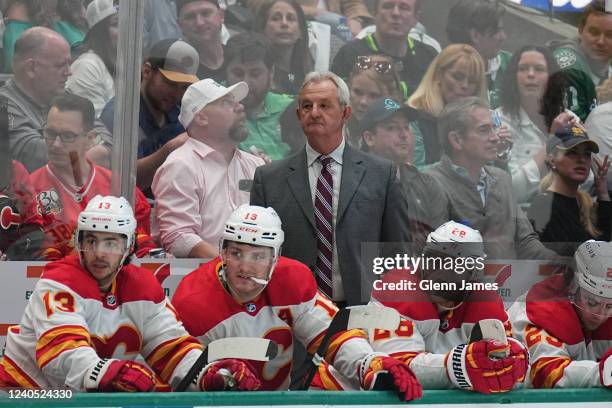 Darryl Sutter pf the Calgary Flames watches the action from behind the bench against the Dallas Stars in Game Three of the First Round of the 2022...