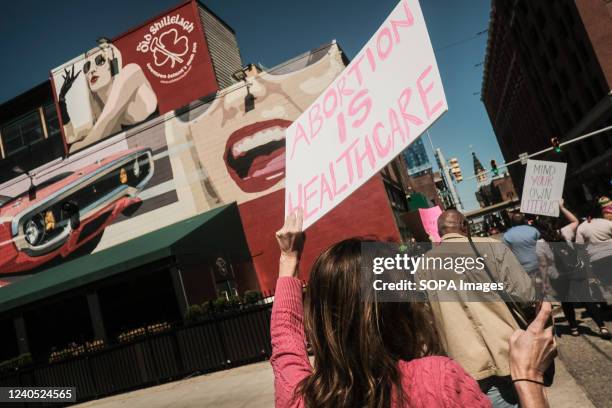 Protesters hold placards, chant, and march through downtown Detroit in support of Roe v Wade. Pro-choice activists march through the streets of...