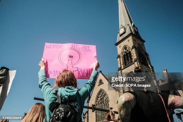 Pro-choice activist holds a placard in support of Roe v Wade in Detroit, Michigan. Pro-choice activists march through the streets of downtown...