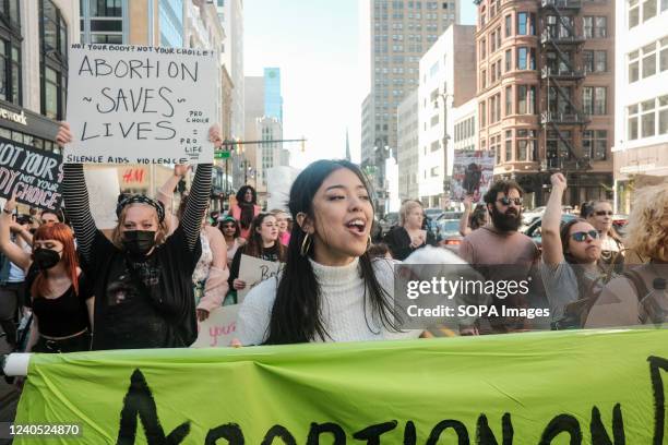 Protesters hold placards, chant, and march through downtown Detroit in support of Roe v Wade. Pro-choice activists march through the streets of...