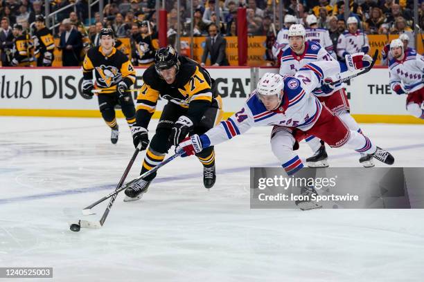 Pittsburgh Penguins center Evgeni Malkin and New York Rangers right wing Kaapo Kakko battle for the puck during the third period in Game Three of the...