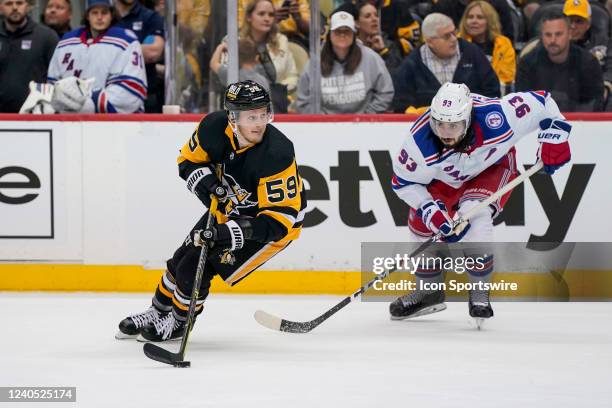 Pittsburgh Penguins left wing Jake Guentzel skates with the puck as New York Rangers center Mika Zibanejad defends during the third period in Game...