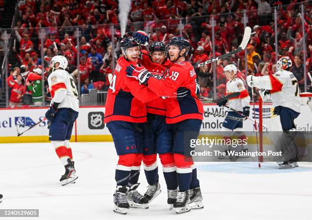 Washington Capitals right wing T.J. Oshie is greeted by John Carlson and Nicklas Backstrom after scoring a first period goal against the Florida...