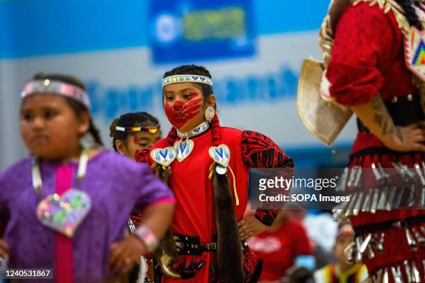 Dancer performs with a red hand print on their face to show solidarity with missing and murdered Indigenous women. The 1st Annual Red Dress Powwow...