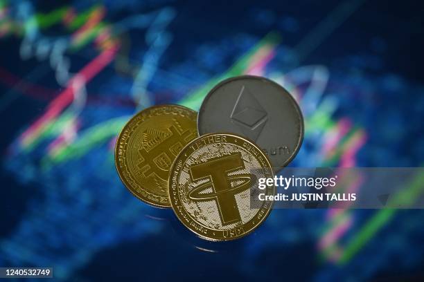 An illustration picture taken in London on May 8 shows gold plated souvenir cryptocurrency Tether , Bitcoin and Etherium coins arranged beside a...