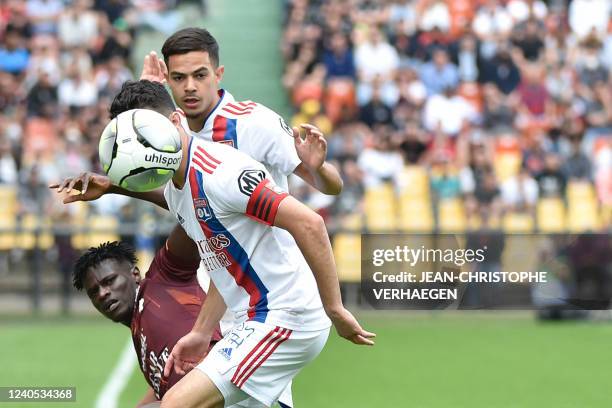 Metzs forward Papa Ndiaga Yade fights for the ball with Lyons French defender Leo Dubois and Lyons French midfielder Romain Faivre during the French...