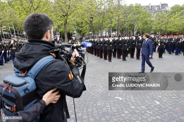 An AFPTV video journalist follows France's President Emmanuel Macron as he reviews troops at the Arc de Triomphe during the ceremonies marking the...