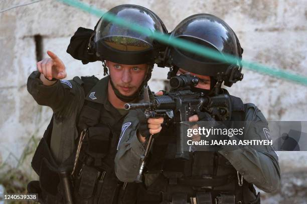 Israeli soldiers takes aim during a raid at house in the town of Rummanah, near the flashpoint town of Jenin in the occupied West Bank on May 8...