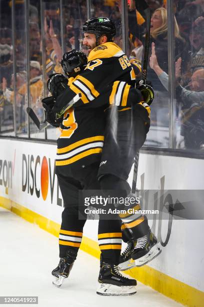 Patrice Bergeron of the Boston Bruins reacts with Brad Marchand after scoring in the first period against the Carolina Hurricanes in Game Four of the...