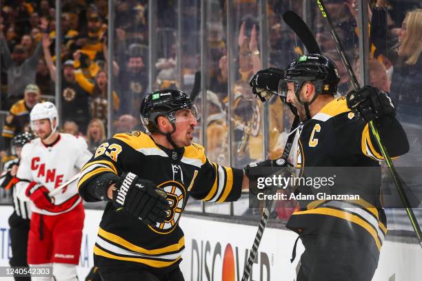 Patrice Bergeron of the Boston Bruins reacts with Brad Marchand after scoring in the first period against the Carolina Hurricanes in Game Four of the...