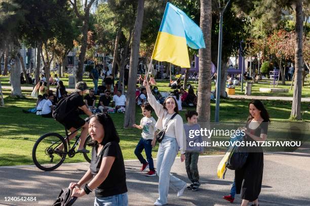 Woman waves a Ukrainian national flag during a demonstration in solidarity with Ukraine in Cyprus' southern port city of Limassol, as Europeans mark...
