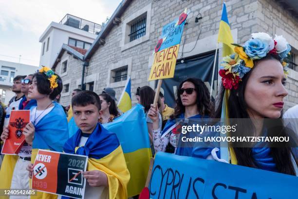 People wave European and a Ukrainian national flags during a demonstration in solidarity with Ukraine in Cyprus' southern port city of Limassol, as...