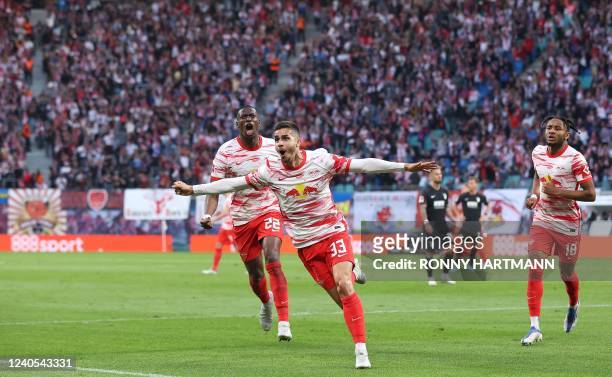 Leipzig's Portugese forward Andre Silva celebrates scoring the opening goal with Leipzig's French defender Nordi Mukiele and Leipzig's French...