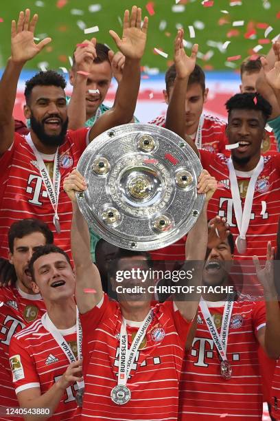 Bayern Munich's Polish forward Robert Lewandowski raises the trophy as Bayern Munich players celebrate after the German first division Bundesliga...