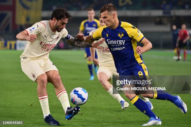 Milan's Italian defender Davide Calabria and Hellas Verona's Serbian midfielder Darko Lazovic go for the ball during the Italian Serie A football...