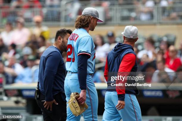 Pitcher Chris Paddack of the Minnesota Twins leaves the game with a medical trainer in the third inning against the Oakland Athletics at Target Field...