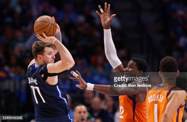 Luka Doncic of the Dallas Mavericks looks to pass around Deandre Ayton of the Phoenix Suns during the first half of Game Four of the 2022 NBA...