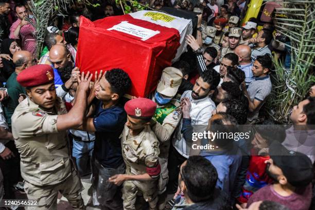 Mourners, soldiers, and military police members carry the casket of Egyptian conscript Ahmed Mohamed Ahmed Ali, one of 11 soldiers killed in an...