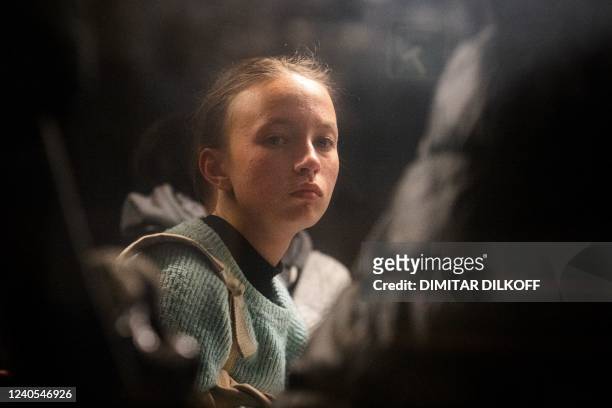 Woman looks out a bus window as people evacuated from Mariupol arrive on buses at a registration and processing area for internally displaced people...