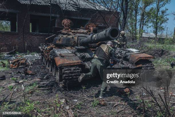 Ukrainian soldiers next to a destroyed Russian tank on the outskirts of Kharkiv, Ukraine, 8 May 2022