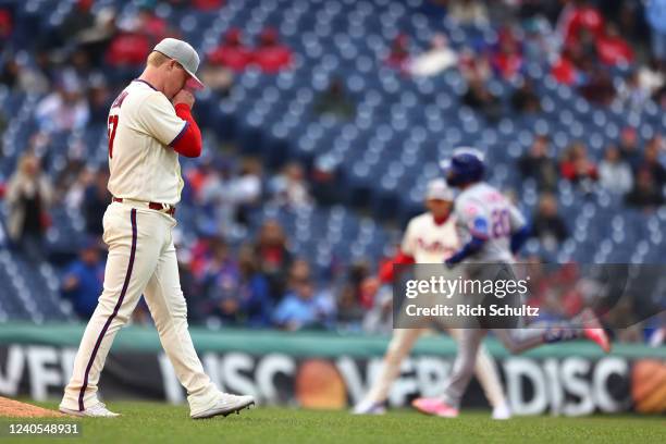 Pitcher Nick Nelson of the Philadelphia Phillies blows on his hand as Pete Alonso of the New York Mets rounds the bases after he hit a three-run home...