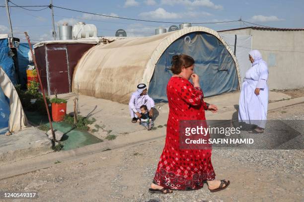 Displaced Yazidis stand near their tent at the Chamishko camp for internally displaced persons in the city of Zakho in the north of Iraq's autonomous...