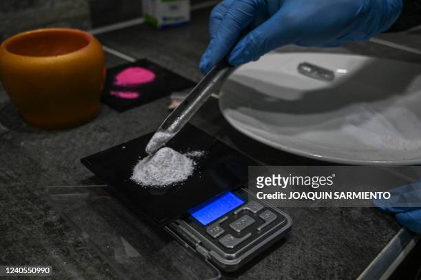 Man weights Ketamine as he prepares a powder known as Tussi or pink cocaine in Medellin, Colombia, on April 2, 2022. - Three decades after Pablo...