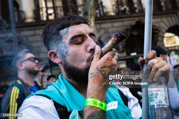 Man smokes a marijuana cigarette as he moves along Mayo Avenue towards the National Congress to demand the decriminalization of cannabis. A crowed...