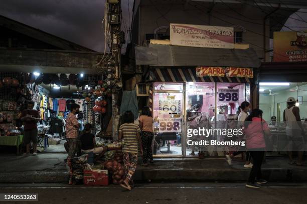 Pedestrians outside stores in Cebu City, the Philippines, on Saturday, May 7, 2022. The Philippines peso is in danger of extending this year's...