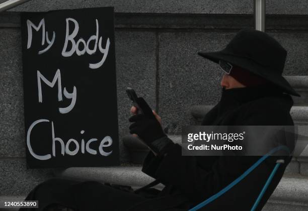An activist seats next to a Pro-Choice poster. Local pro-Choice activists gathered at the Alberta Legislature in solidarity with US women to protest...