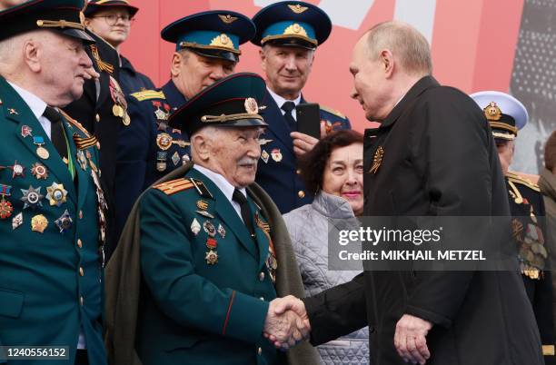 Russian President Vladimir Putin greets veterans as he arrives to watch the Victory Day military parade at Red Square in central Moscow on May 9,...