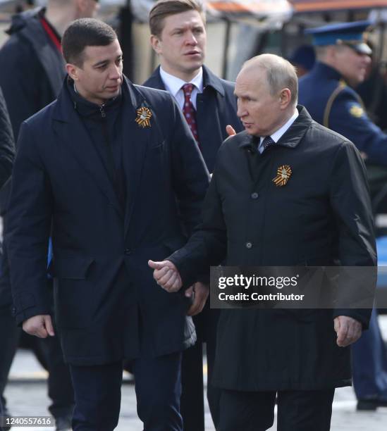 Russian President Vladimir Putin talks to Presidential Press Service Aide Dmitry Kovalyov during the Victory Day Parade at Red Square on May 9, 2022...