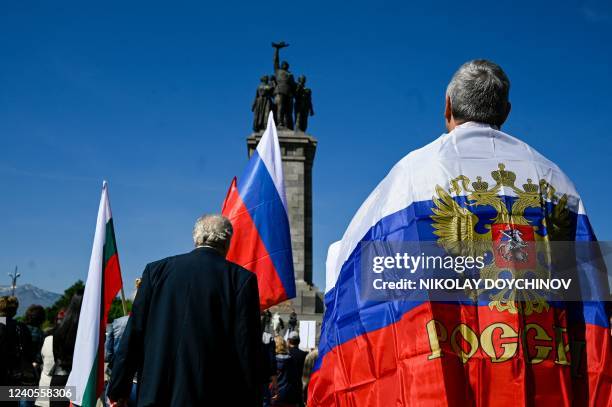 Man wrapped in a Russian flag stands in front of the Soviet Army monument in Sofia on May 9 during a celebration of the Victory Day marking the 77th...