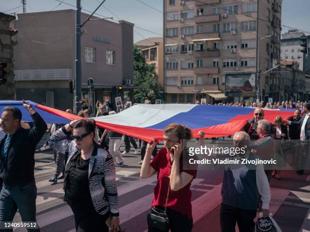 People carry big Russian flag during the "Immortal Regiment" march on May 9, 2022 in Belgrade, Serbia. About 200 people took part in the march of the...