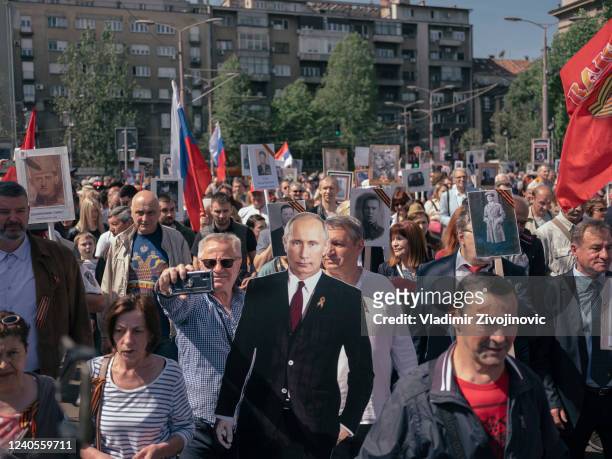 Man holds a cutout of Russian President Vladimir Putin during the "Immortal Regiment" march on May 9, 2022 in Belgrade, Serbia. About 200 people took...