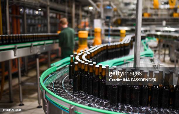 Beer bottles on a conveyor belt are pictured in the bottling plant at the Veltins brewery in Grevenstein, western Germany on May 9, 2022. The Veltins...