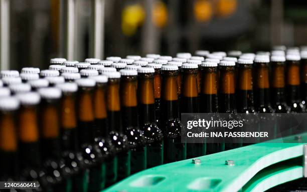 Photo shows beer bottles on a conveyor belt in the bottling plant at the Veltins brewery in Grevenstein, western Germany on May 9, 2022. The Veltins...