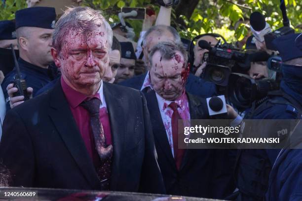 Russian Ambassador to Poland Sergey Andreev gets in his car after being covered with red paint during a laying wreath ceremony at the Soviet soldier...