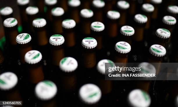 Beer bottles on a conveyor belt are pictured in the bottling plant at the Veltins brewery in Grevenstein, western Germany on May 9, 2022. The Veltins...