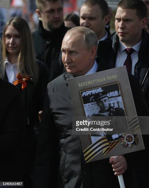 Russian President Vladimir Putin holds a portrait of his father during the Immortal Regiment, a rally of muscovits with portraits of their...