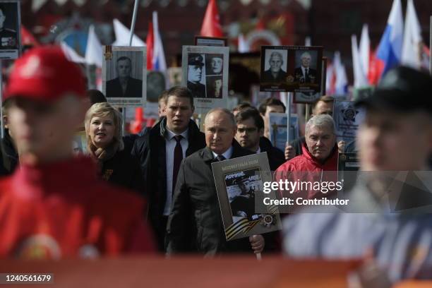 Russian President Vladimir Putin holds a portrai of his father during the Immortal Regiment, a rally of muscovits with portraits of their...