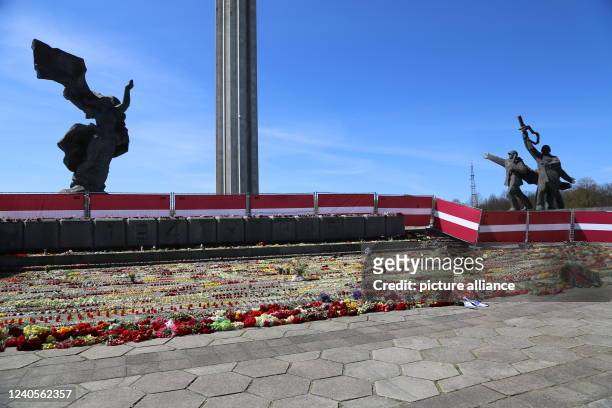May 2022, Latvia, Riga: A sea of flowers lies at the fenced-off Soviet Victory Monument in Riga on "Victory Day." Overshadowed by Russia's war...
