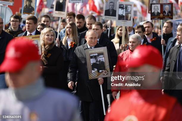 Russian President Vladimir Putin holds a portrait of his father during the Immortal Regiment, a rally where people carrying portraits of their...