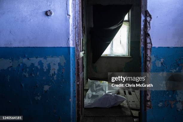 The body of a Ukrainian soldier killed in fighting around Popasna is seen in a room at a frontline field hospital before being transported to a...