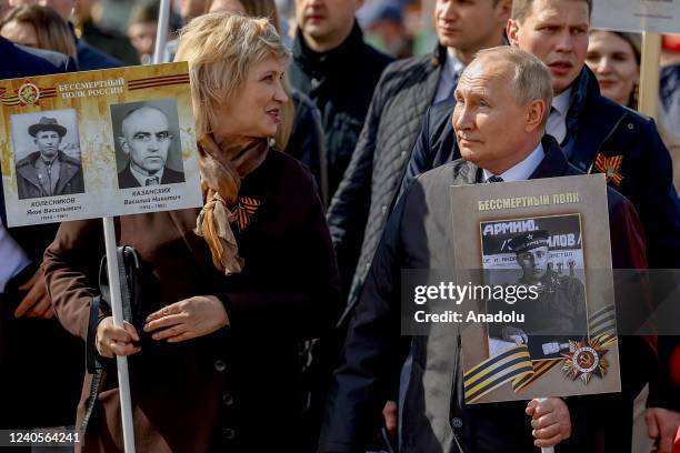 Russian President Vladimir Putin holds a portrait of his father during the Immortal Regiment, a rally where people carrying portraits of their...